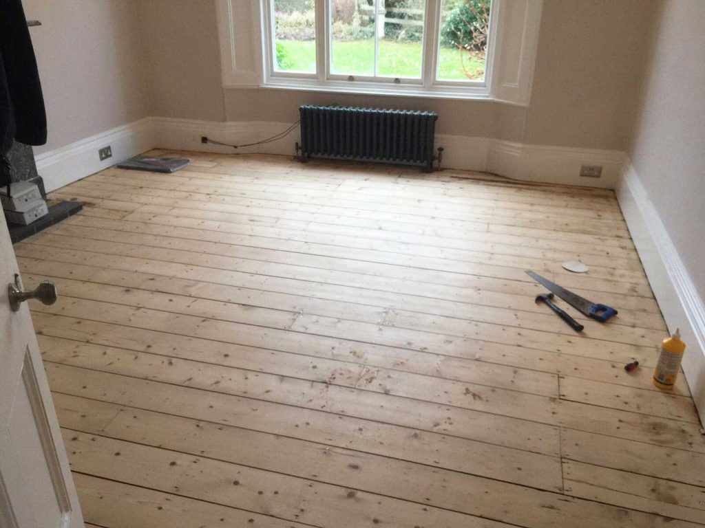 Sanding the wooden floor boards