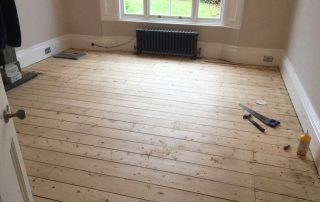 Sanding the wooden floor boards