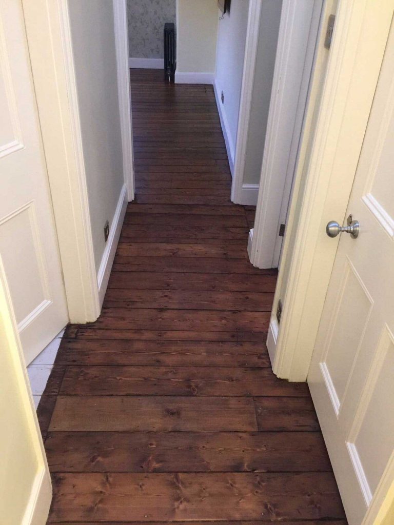 These wooden floor boards have been sanded then stained with a Dark Oak Staining