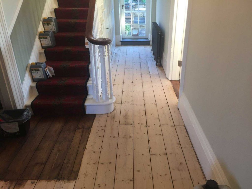 Wooden floor boards are sanded then stained with a Dark Oak Staining